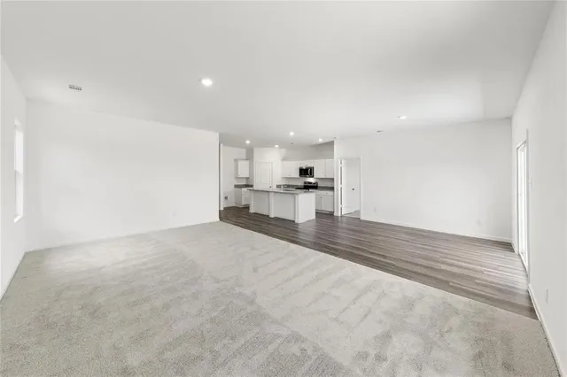 a view of empty room with a kitchen