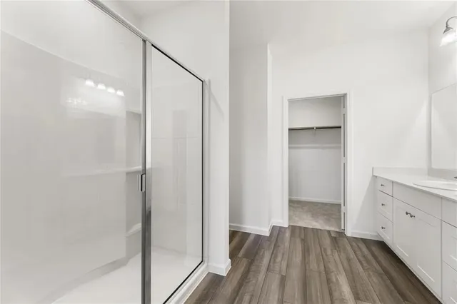 a view of bathroom with a hardwood and shower