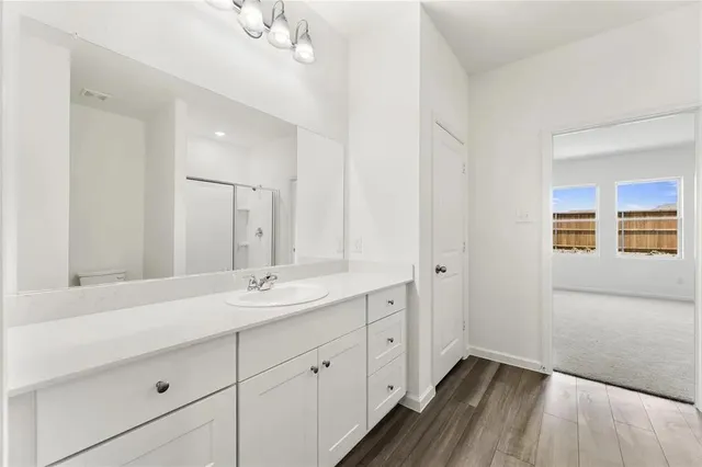 a bathroom with a double vanity sink and mirror with shower