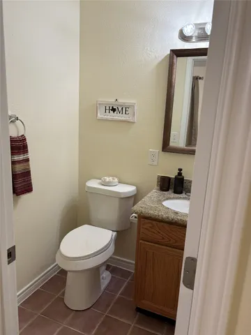 a bathroom with a granite countertop toilet and a sink