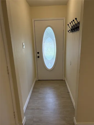 an empty room with wooden floor mirror and door