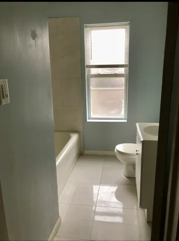 a bathroom with a toilet a sink and a window