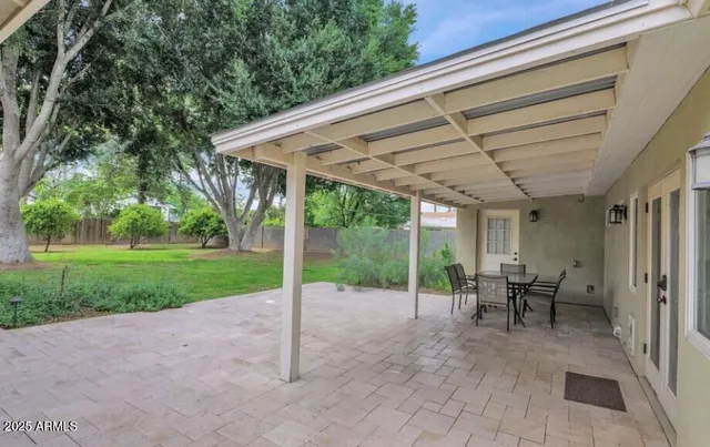 a view of a patio with table and chairs next to a yard