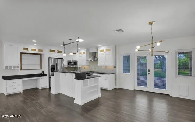 a kitchen with stainless steel appliances kitchen island a refrigerator and a sink