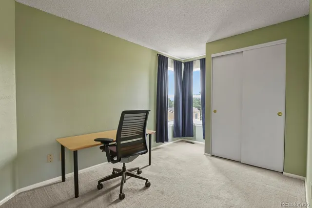 a view of a workspace with furniture and a window
