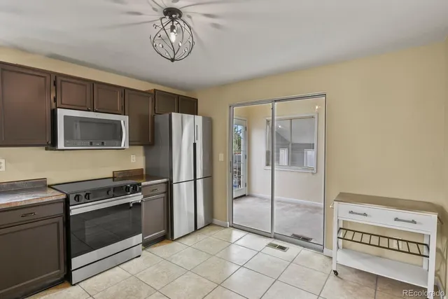 a kitchen with granite countertop a refrigerator and a stove top oven