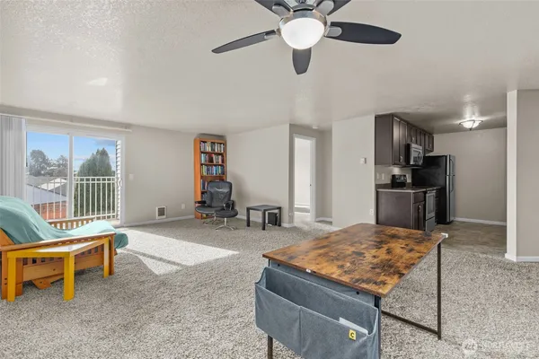 a living room with a dining table and paintings on the wall