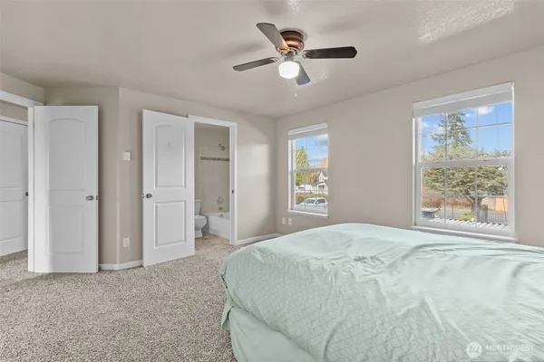 a spacious bedroom with a large bed a chandelier and a window