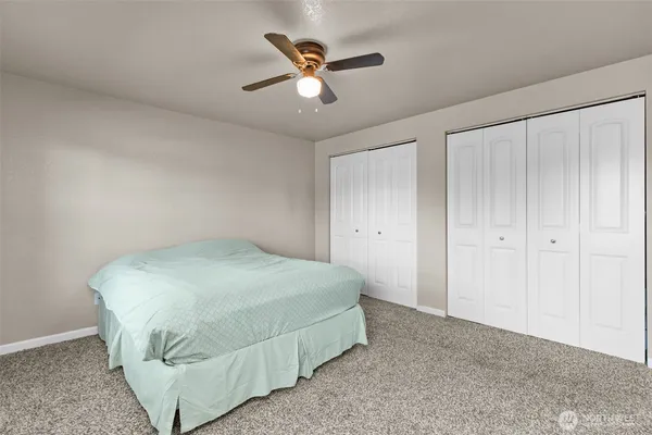 a bedroom with a bed and a ceiling fan