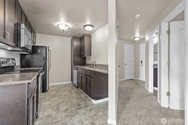 a large kitchen with a refrigerator and a sink