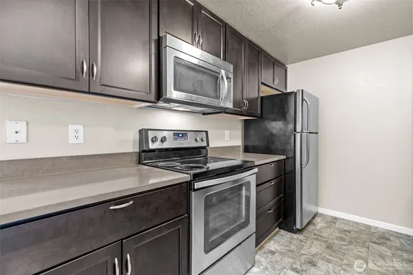 a kitchen with stainless steel appliances granite countertop a stove microwave and refrigerator