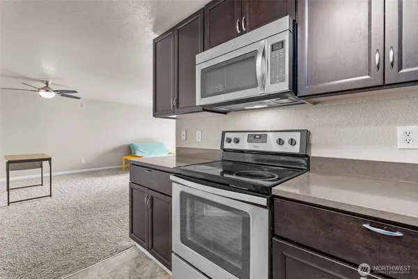 a kitchen with stainless steel appliances granite countertop a stove microwave and sink