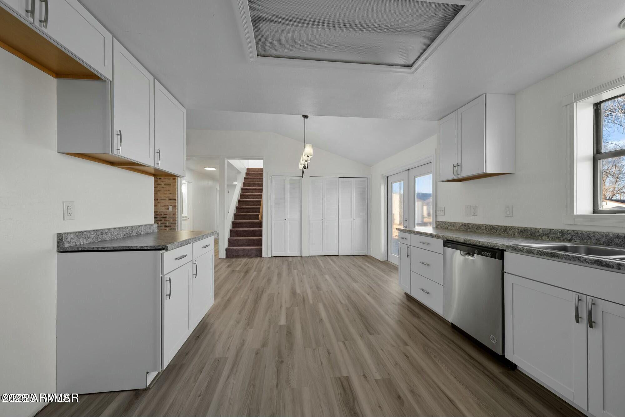 723 Tori Circle Springerville, AZ 85938 - Photo 20 of 47 a kitchen with granite countertop wooden floors a sink stainless steel appliances and cabinets