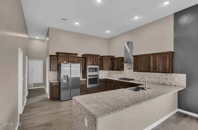 a kitchen with stainless steel appliances granite countertop a refrigerator and a sink