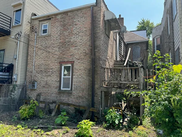 a view of a brick house with a flower garden