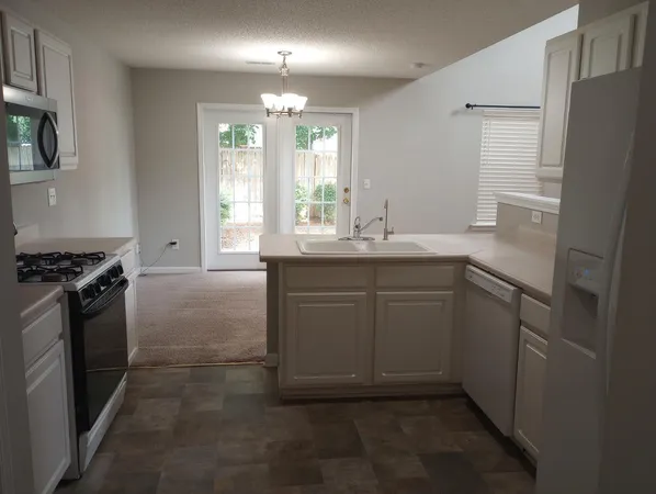 a kitchen with a sink stove and refrigerator