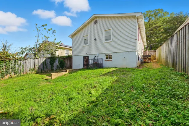 a view of a house with backyard and a tree