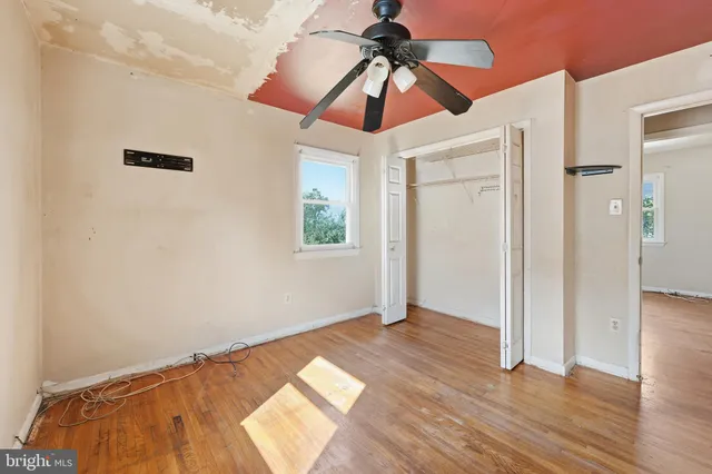 a view of empty room with wooden floor