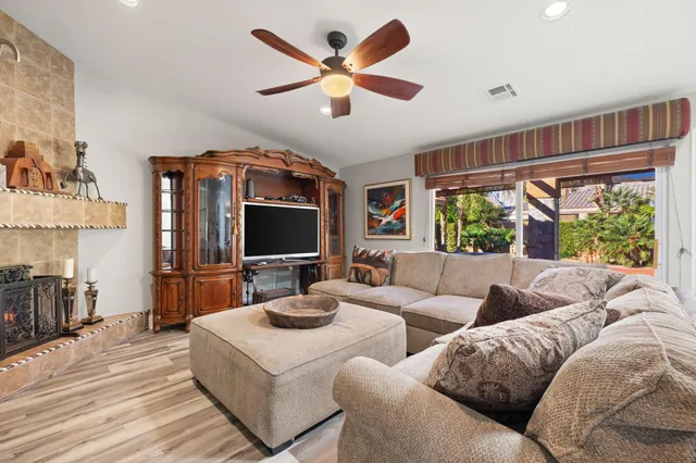 a dining room with wooden floor a chandelier a wooden table and chairs