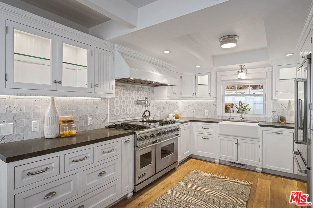 19236 Pacific Coast Highway Malibu, CA 90265 - Photo 18 of 41 a kitchen with granite countertop white cabinets and white appliances