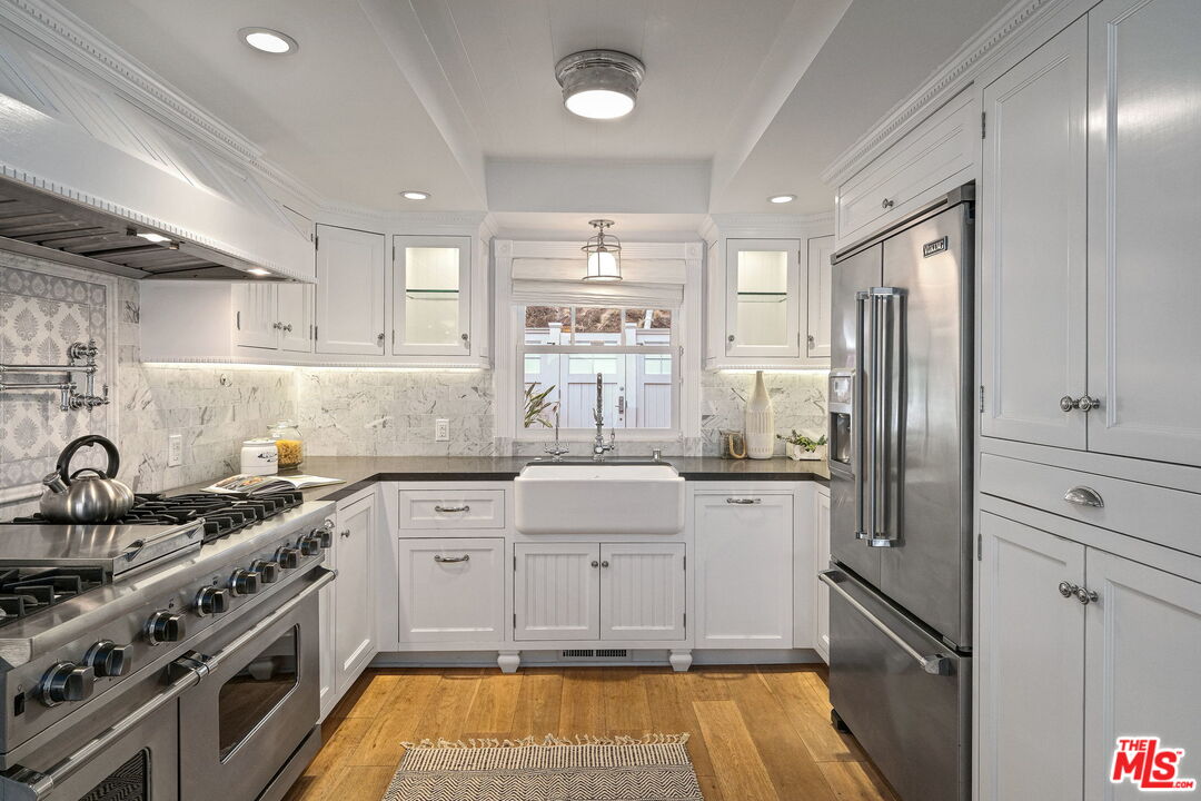 19236 Pacific Coast Highway Malibu, CA 90265 - Photo 19 of 41 a kitchen with stainless steel appliances granite countertop a sink stove and refrigerator