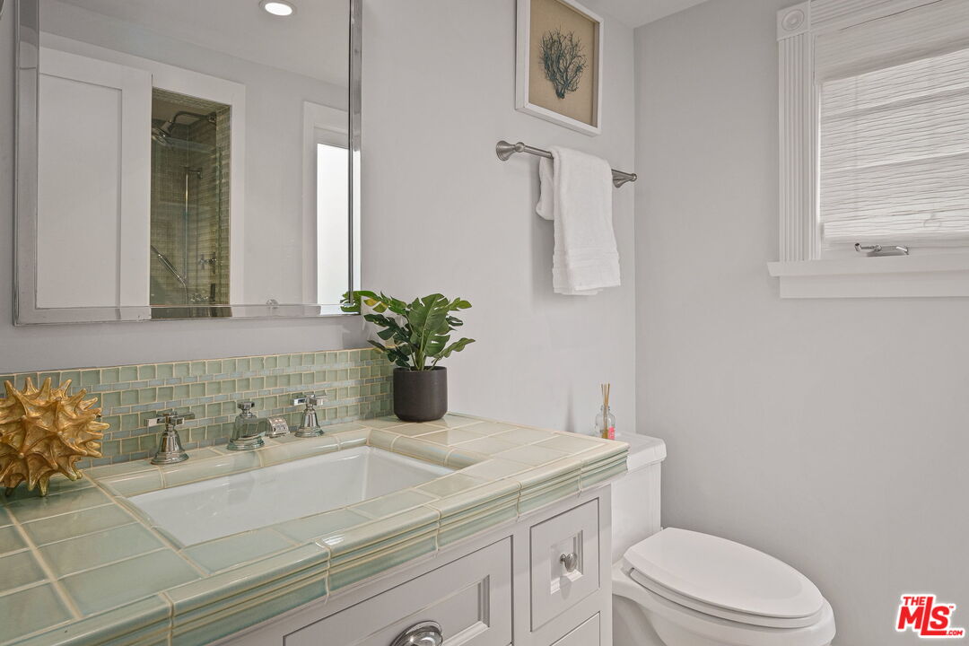 19236 Pacific Coast Highway Malibu, CA 90265 - Photo 21 of 41 a bathroom with a sink a toilet and mirror