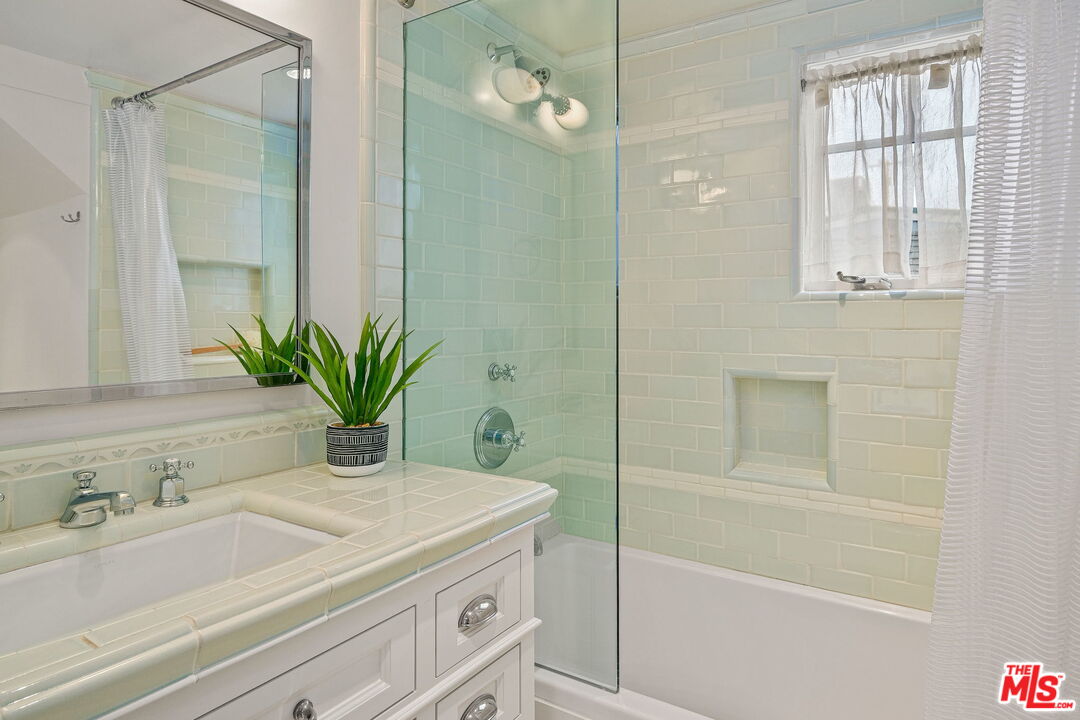 19236 Pacific Coast Highway Malibu, CA 90265 - Photo 26 of 41 a bathroom with a granite countertop sink a mirror a vanity and a bathtub