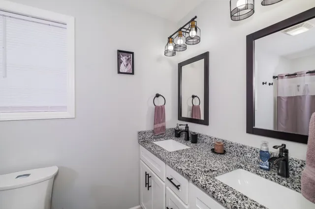 a bathroom with a granite countertop sink and a mirror