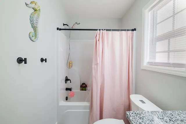 a bathroom with a shower curtain and a window