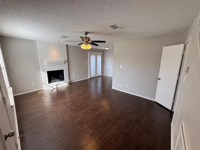 an empty room with wooden floor and fireplace