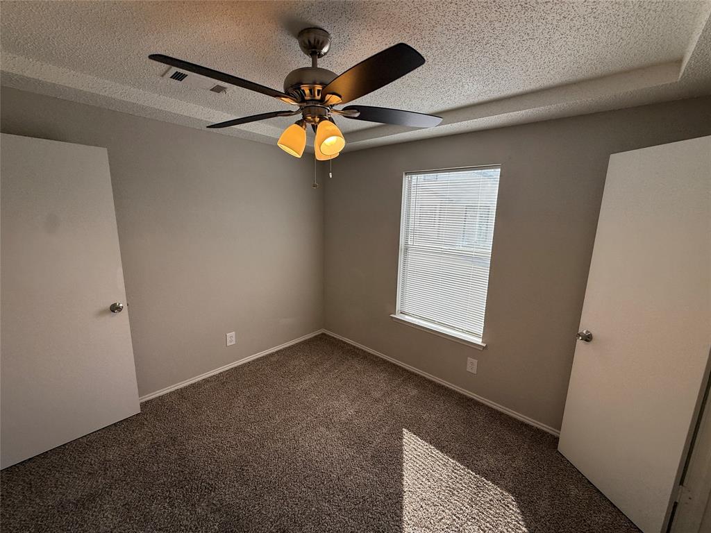 5908 Holiday Lane, Unit C North Richland Hills, TX 76180 - Photo 8 of 18 an empty room with windows and fan