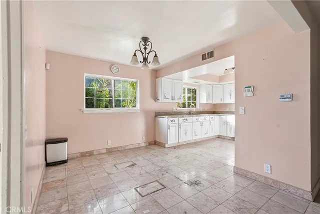 a kitchen with stainless steel appliances granite countertop a sink stove oven and white cabinets