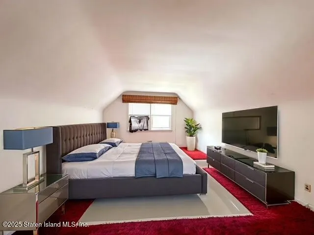 a living room with a bed and a flat screen tv