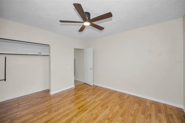 a view of a big room with wooden floor and a ceiling fan