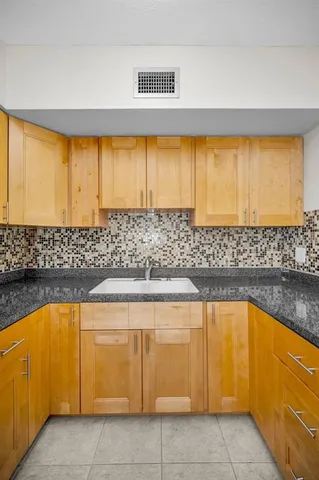 a view of a kitchen with kitchen island sink and granite counter top