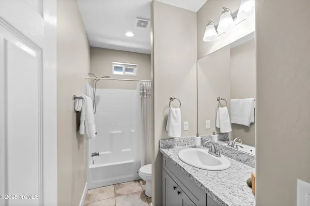 a bathroom with a granite countertop sink mirror toilet and bathtub