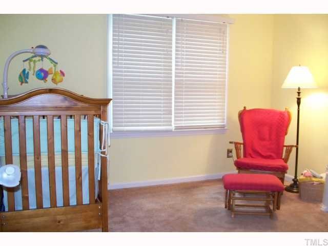 4412 Liverpool Lane Raleigh, NC 27604 - Photo 8 of 12 a bedroom with a bed and a chair