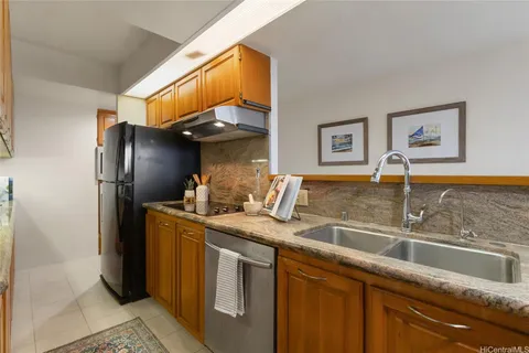 a kitchen with stainless steel appliances granite countertop a sink and a refrigerator