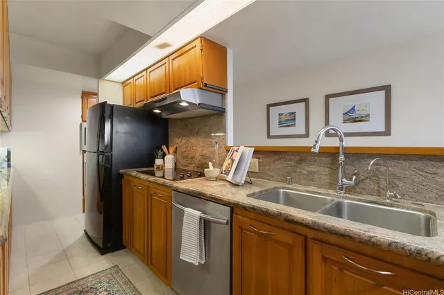 a kitchen with stainless steel appliances granite countertop a sink and a refrigerator