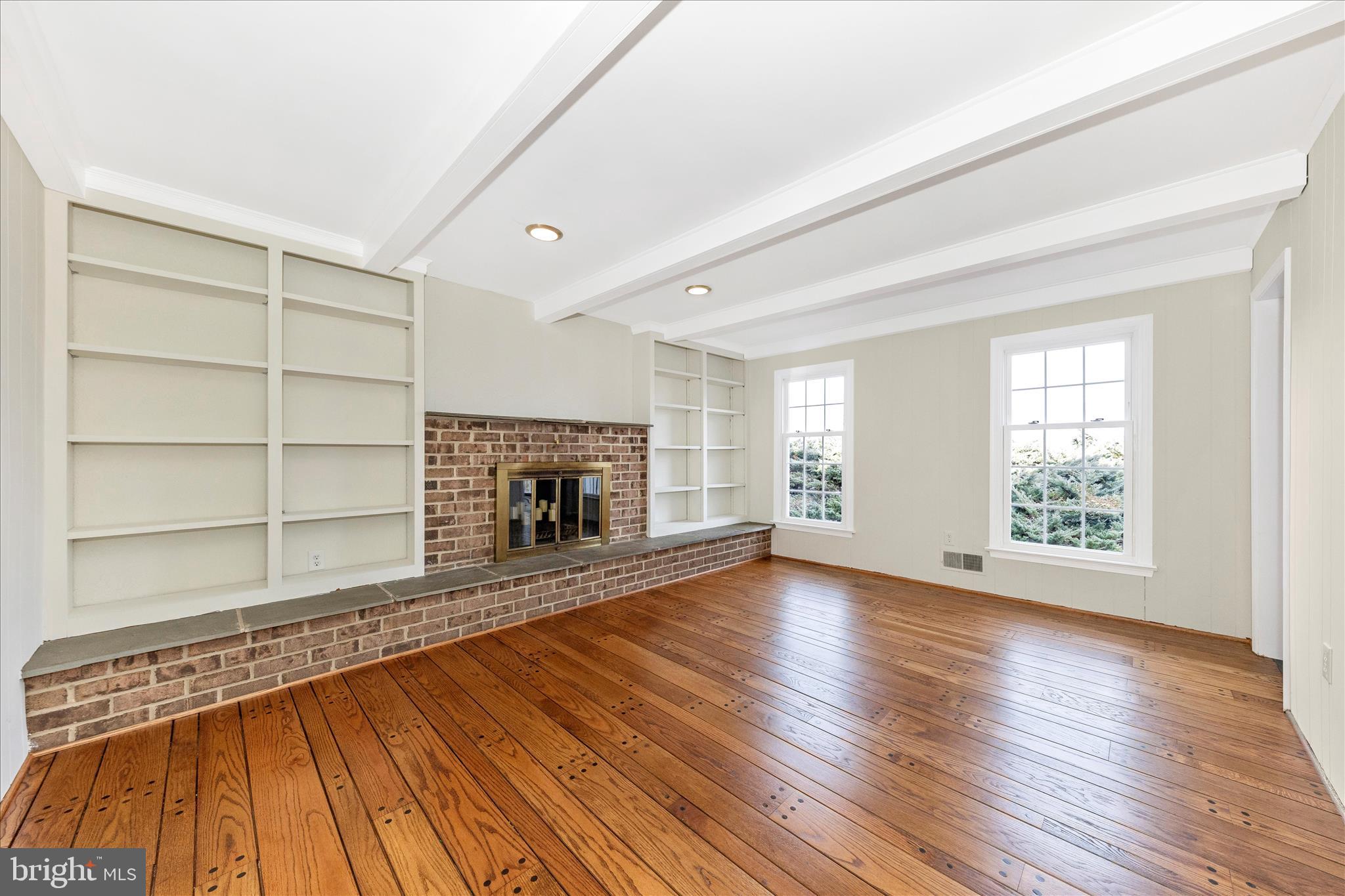 5815 Meadow Road Frederick, MD 21702 - Photo 18 of 55 an empty room with wooden floor fireplace and windows