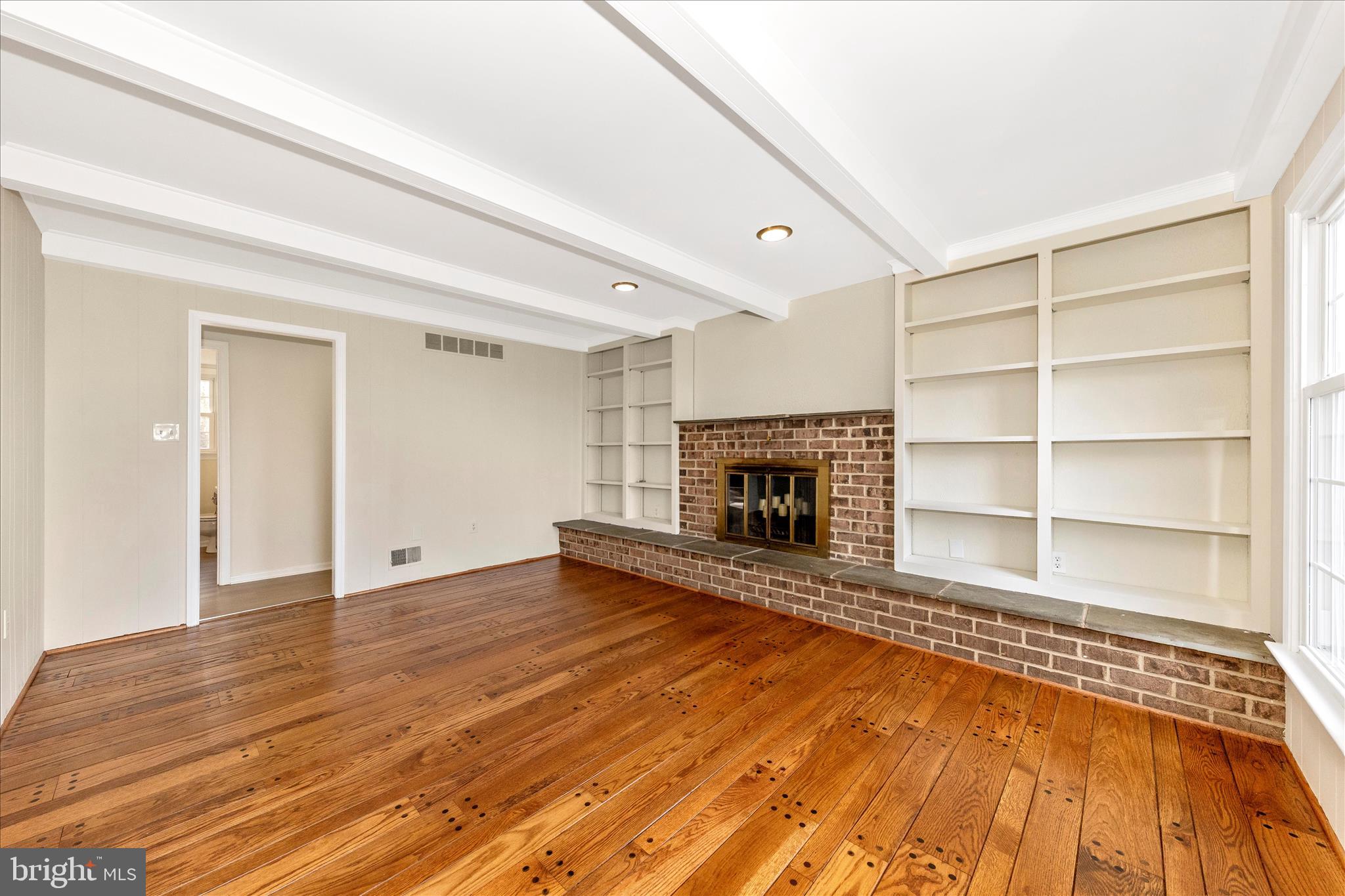 5815 Meadow Road Frederick, MD 21702 - Photo 20 of 55 a view of an empty room with wooden floor fireplace and a window