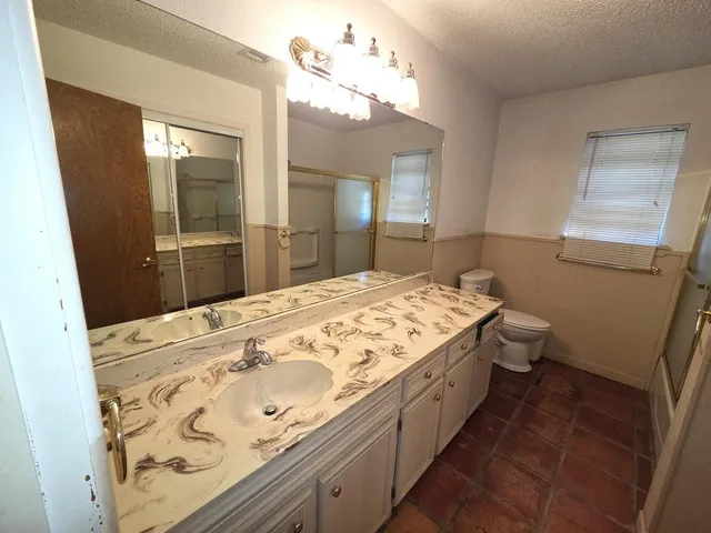 a bathroom with a glass shower door and a sink