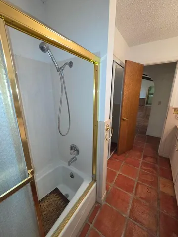 a bathroom with a granite countertop sink a toilet a mirror and bathtub