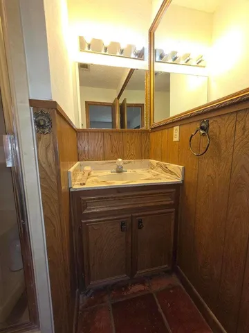 a bathroom with a shower sink and mirror