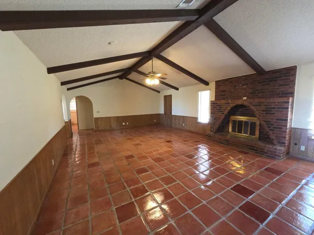 a view of a hallway with wooden floor and a large window
