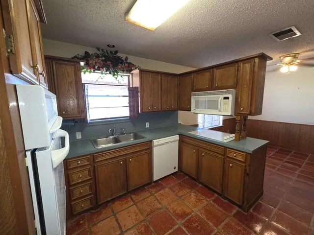 a kitchen with a sink a window and cabinets