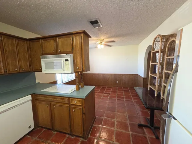 en empty room with windows and chandelier fan
