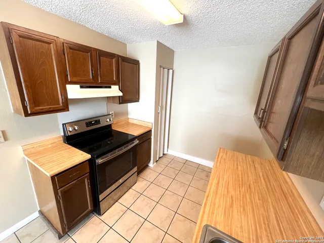 a kitchen with wooden cabinets and a stove top oven