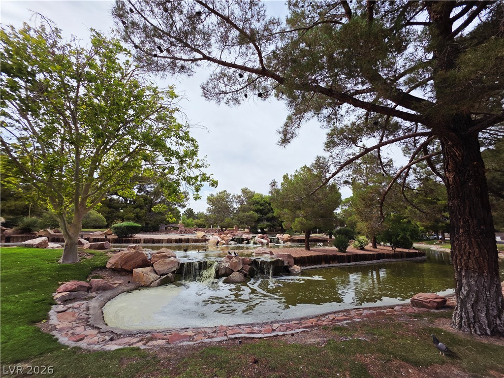 2920 Setting Sun Street Las Vegas, NV 89117 - Photo 5 of 43 A tranquil water feature with natural rock formations and lush surrounding trees.