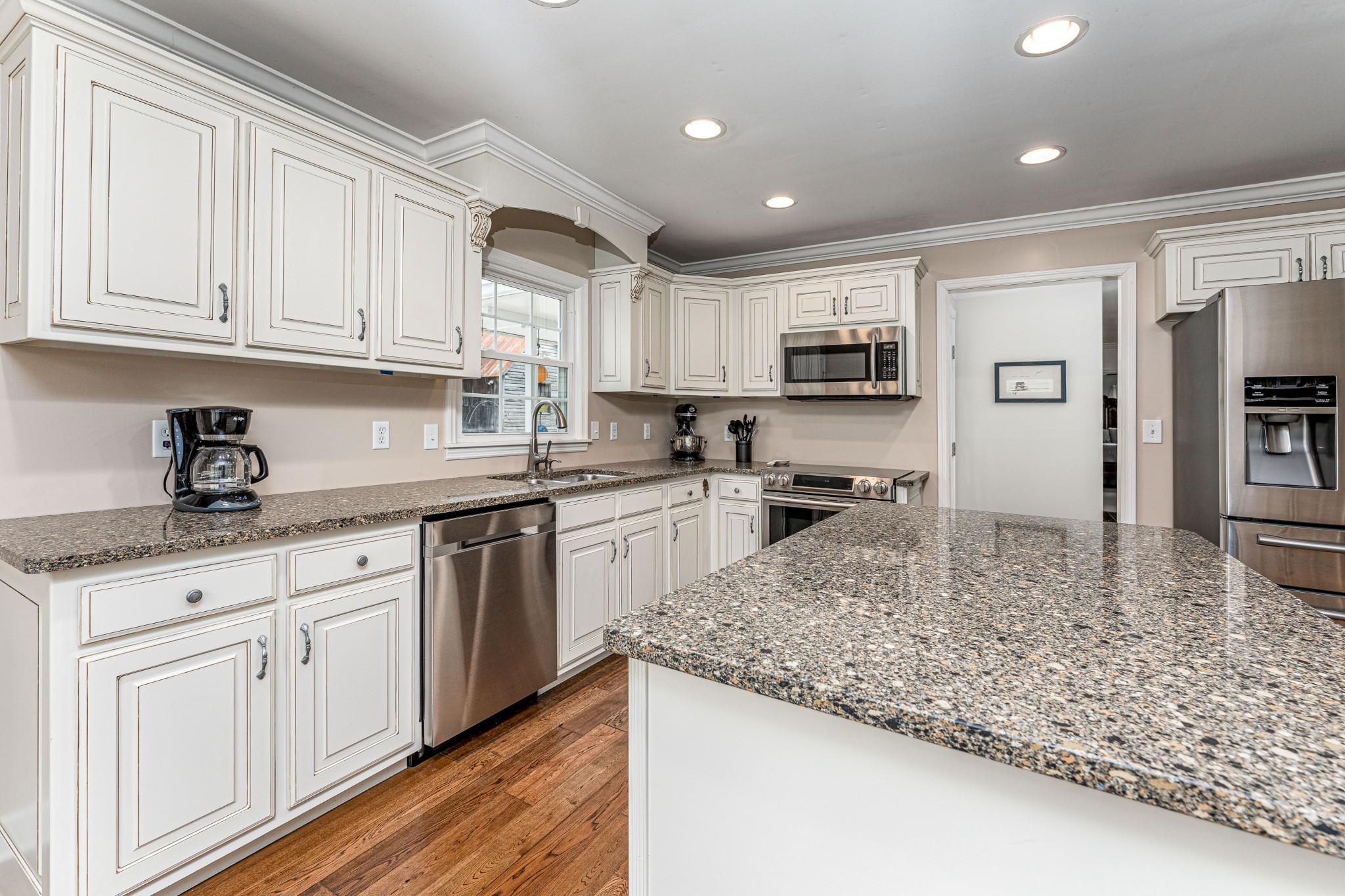 4861 Bethesda Road Thompson's Station, TN 37179 - Photo 9 of 22 a kitchen with granite countertop a sink stainless steel appliances and white cabinets